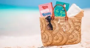 a beach bag with romance book covers poking out