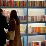 two people looking at books in a bookstore