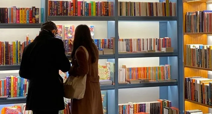 two people looking at books in a bookstore