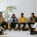 Black people of various skin tones sitting in a circle and discussing books