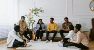 Black people of various skin tones sitting in a circle and discussing books