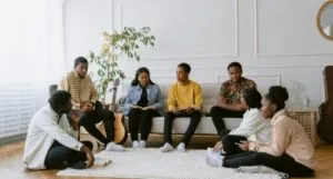 Black people of various skin tones sitting in a circle and discussing books