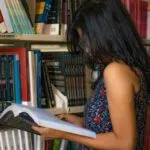 a light brown skinned woman reading