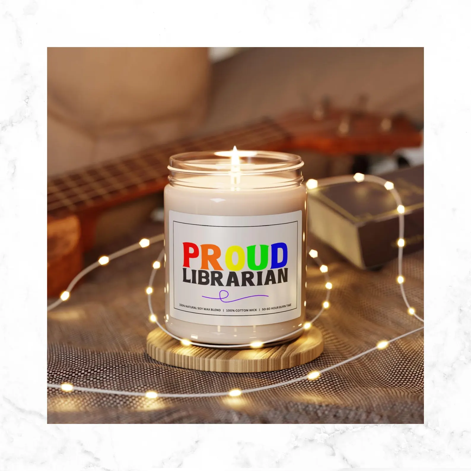 Image of a white candle in a glass jar. The label on the candle says "Proud librarian." Proud is in rainbow colors. 