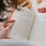 someone reading a book with fruit in the background