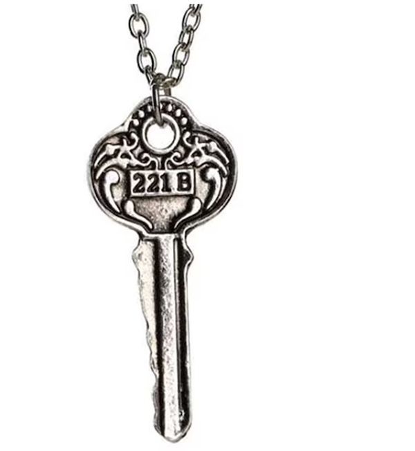 an antique silver key on a silver chain. The key is engraved with "221 B"