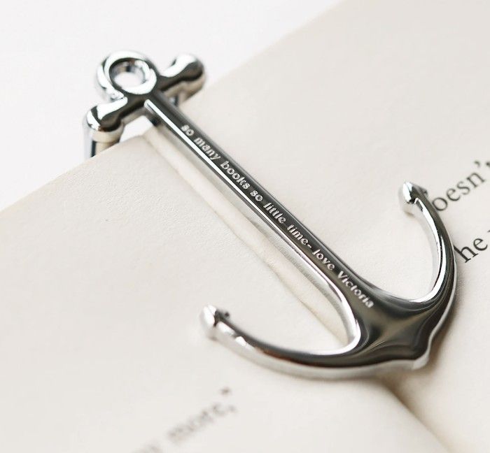 Ancla de libro de metal de plata que alberga una página