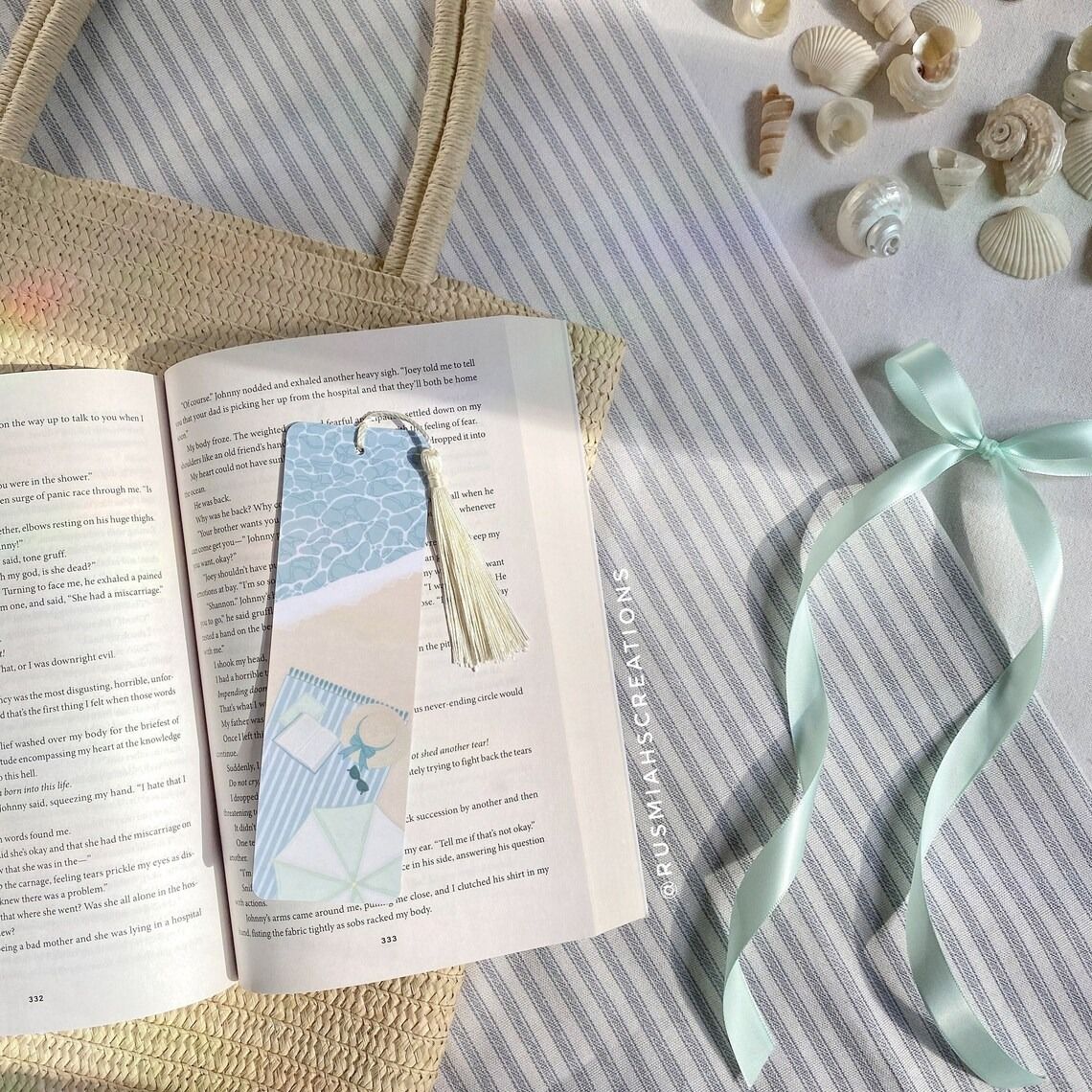 Two bookmarks with the same illustration: shore, beach towel, hat and book. Bookmarks are on sand.
