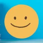 big yellow smiley face next to stack of books against blue background