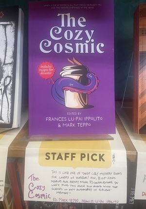 copy of the book The Cozy Cosmic on a shelf at a bookstore with a Staff Pick shelf talker attached