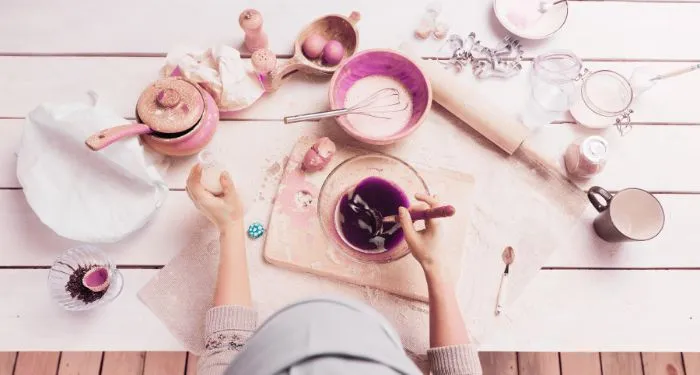 overhead image of someone baking with ingredients, measuring bowl, and mixing bowls spread out on a counter