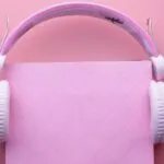 pink headphones on a pink book on a pink background