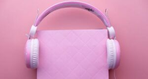 pink headphones on a pink book on a pink background