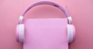 pink headphones on a pink book on a pink background