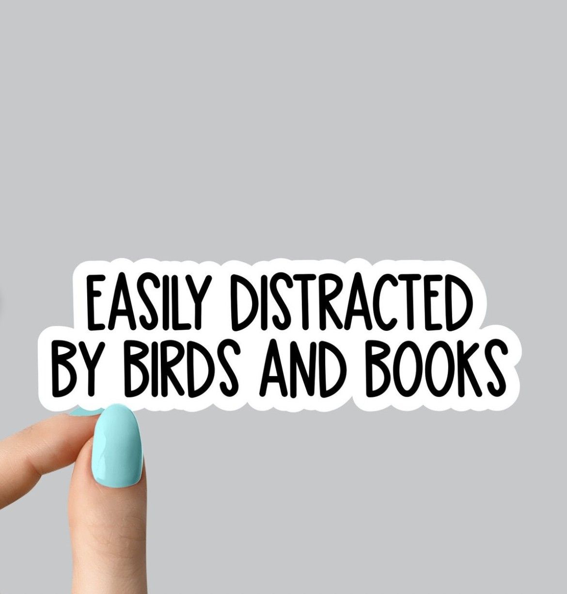 Image of a vinyl sticker with text "easily distracted by birds and books"