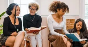 a group of Black and brown women reading and discussing books