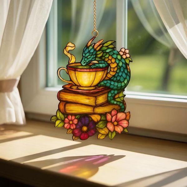 Un chorlito acrílico en una taza de té, un libro que bebe de la taza con un dragón y la pila de flores posadas