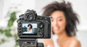 Image of a Black woman in front of a camera
