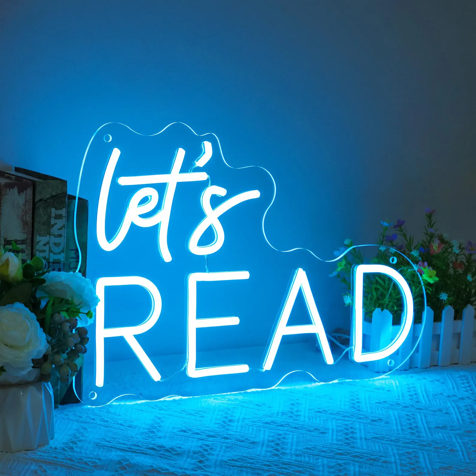 Image of a blue neon sign that says "let's read."