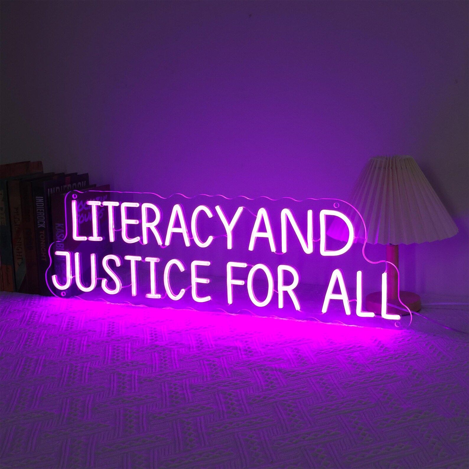Neon pink sign that reads "literacy and justice for all."