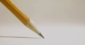 pencil about to write on blank sheet of paper