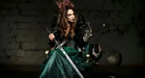 fair-skinned woman dressed in medieval-inspired garb and holding a long sword