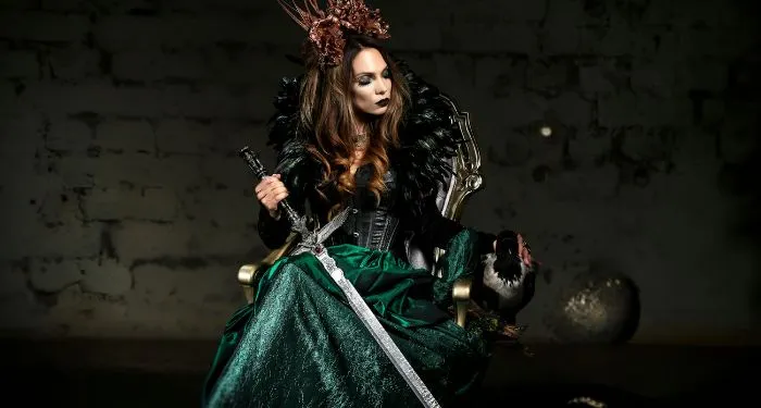 fair-skinned woman dressed in medieval-inspired garb and holding a long sword