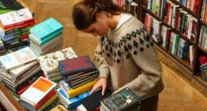 a fair-skinned person looking at a book table
