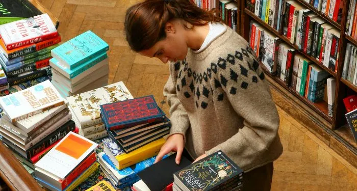 a fair-skinned person looking at a book table