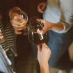 group of different people holding wine glasses
