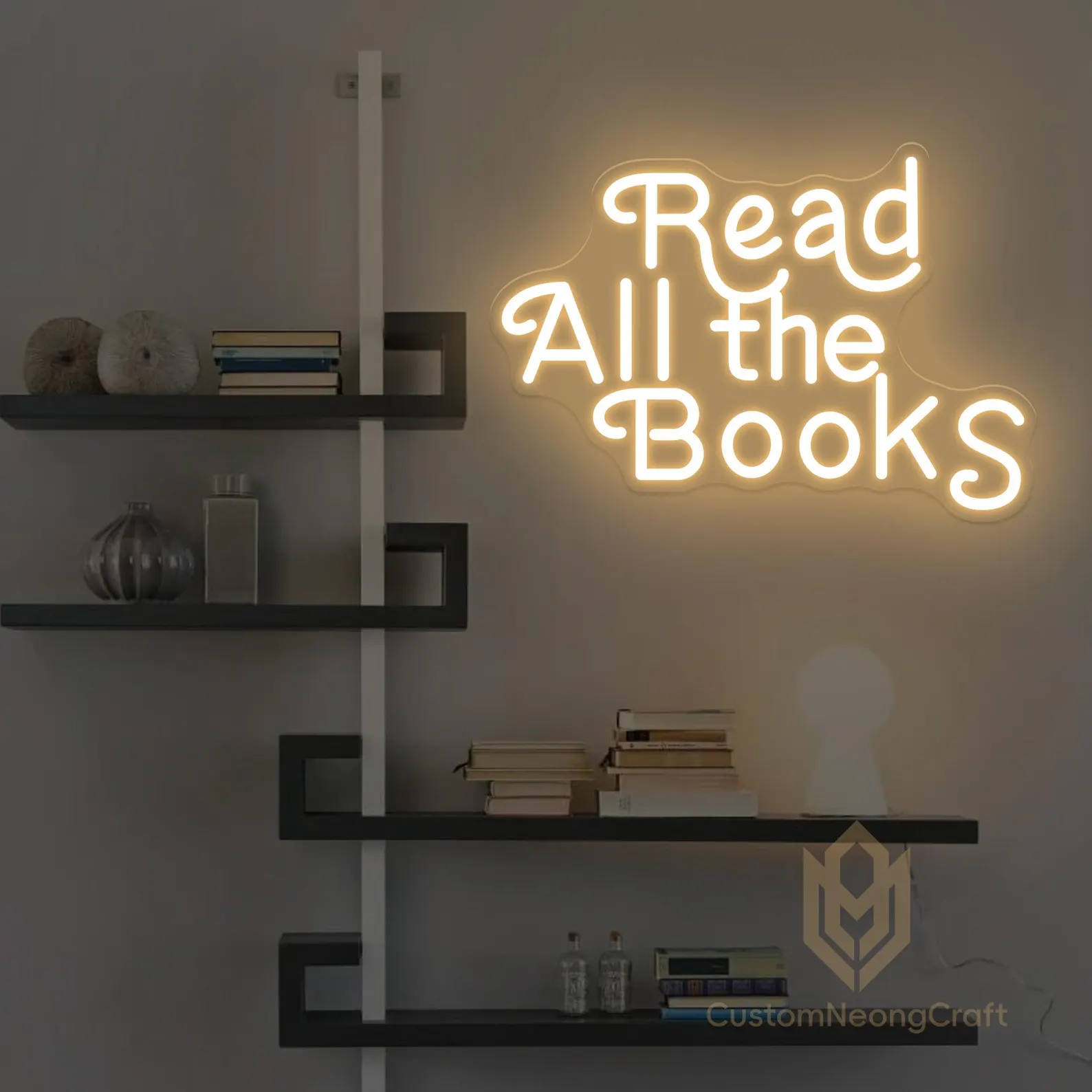 Image of a yellow neon sign on a wall that says "read all the books."