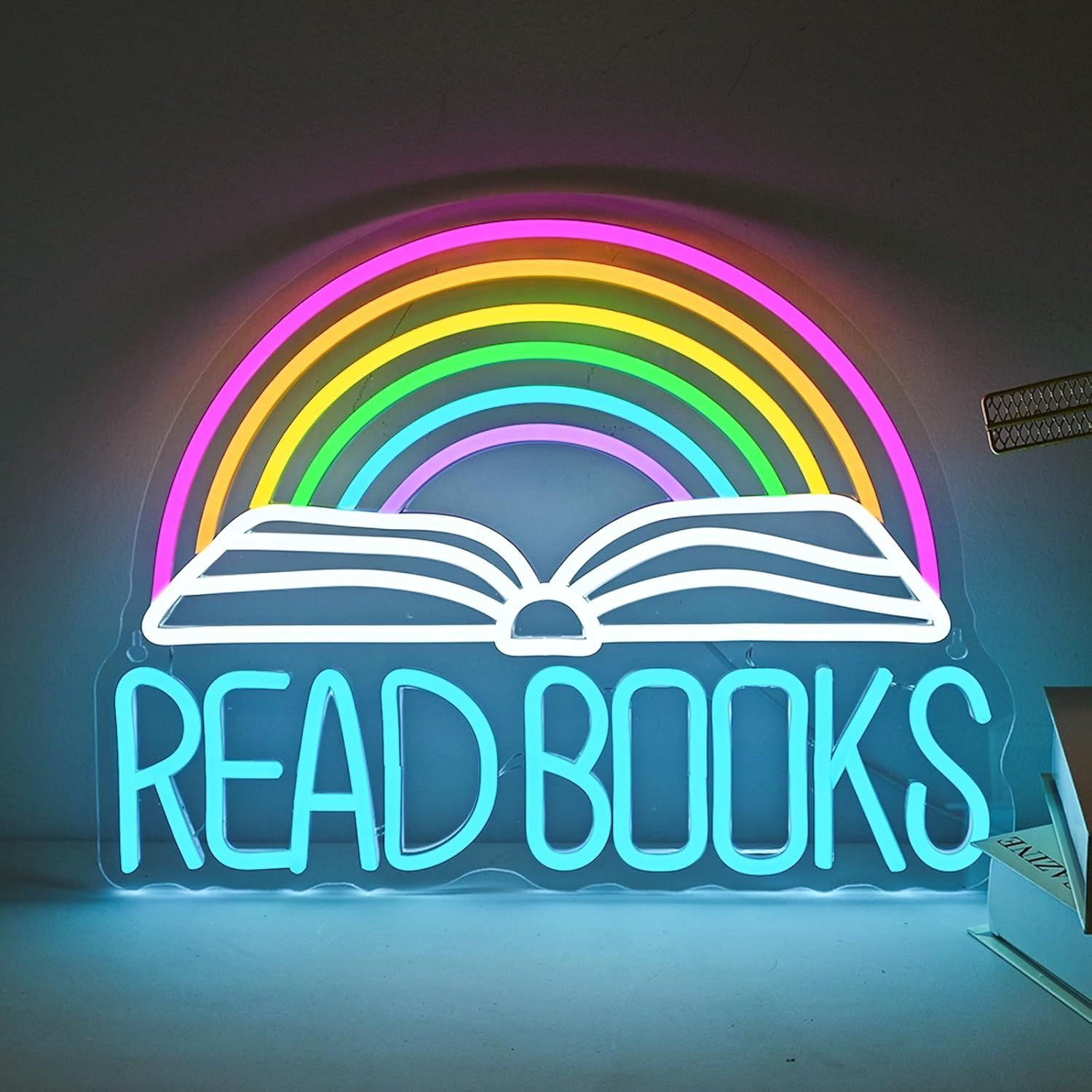 Image of a neon sign that says "read books." There is an open book above the words and a rainbow above the open book. 