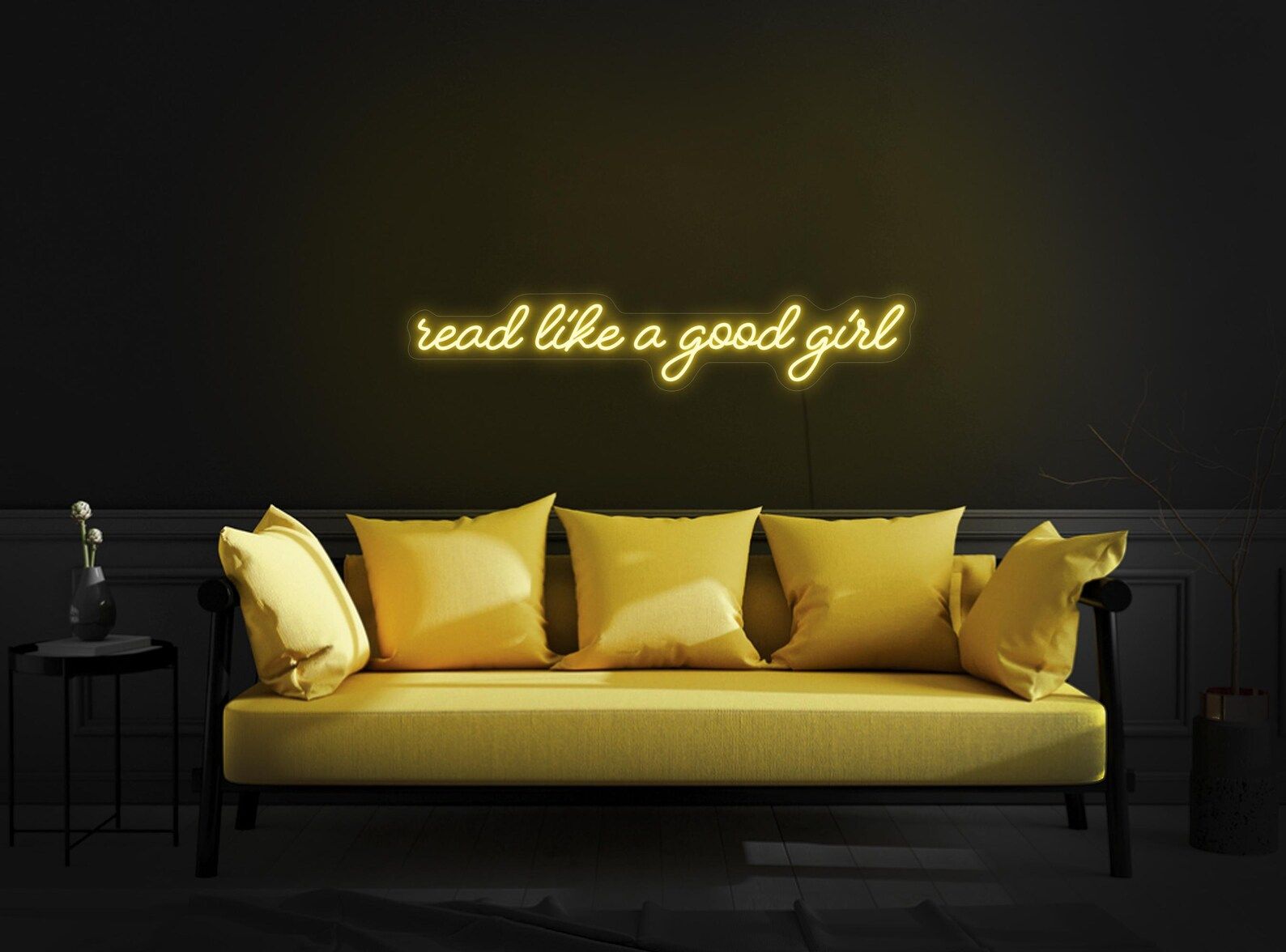 Image of a yellow neon sign over a yellow couch. The sign says "read like a good girl."