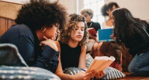 a group of young women of color reading together