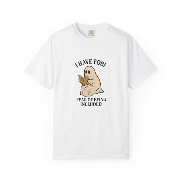 white t-shirt with a graphic of a ghost reading a book with black text bordering the image that reads "I have FOBI, fear of being included"