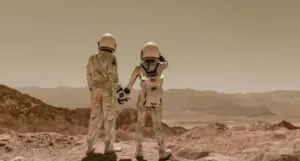 two people in astronaut suits holding hands in a desert-like environment