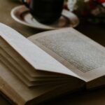 open book near a mug on a table