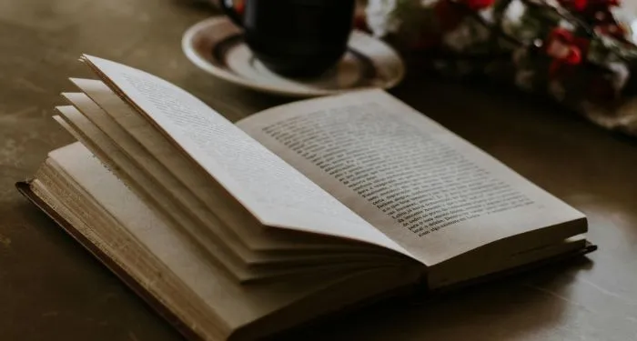 open book near a mug on a table