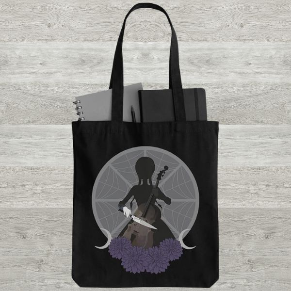 a black tote bag with a silhouette of Wednesday Addams playing the cello using a knife in place of a bow