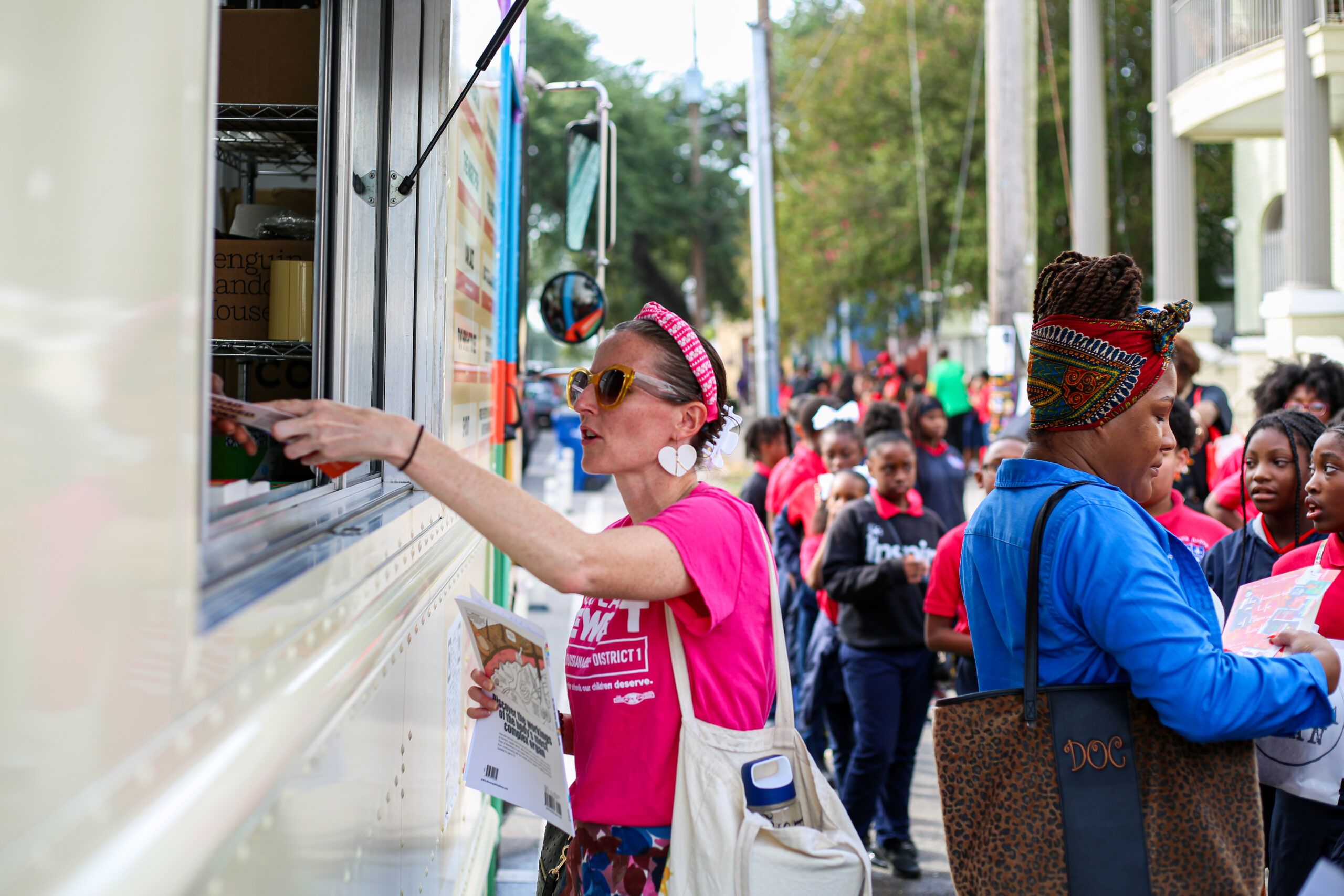 a photo of someone at the window of the Banned Wagon, with a line behind them