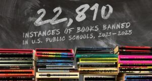 Image of a stack of banned books. They're in front of a chalkboard that notes there have been 22,810 instances of book bans in us public schools since 2021