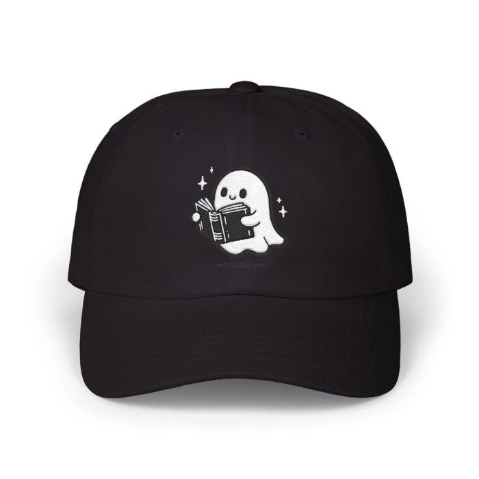 An image of a black baseball cap with a simple white decoration of a cartoon ghost reading a book.