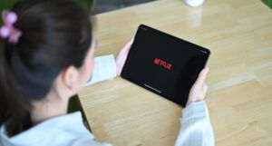 a person holding a tablet loading Netflix