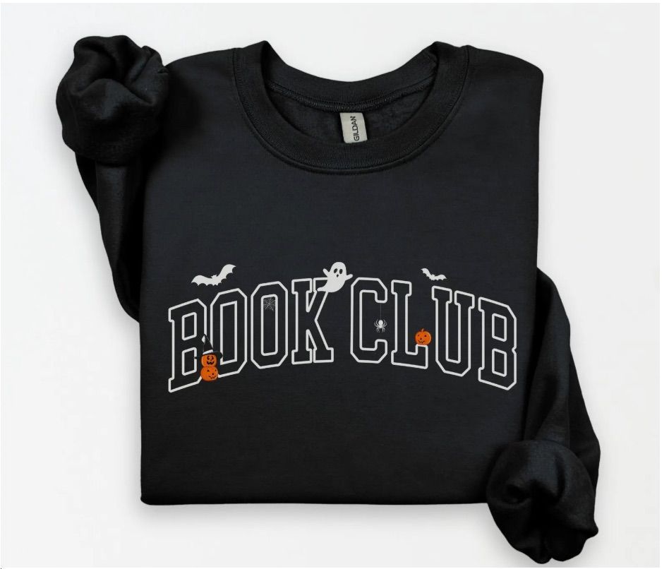 Image of a black sweatshirt with the white letters spelling out "book club." There are bats, ghosts, pumpkins, and a spider surrounding the words. 