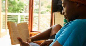 brown-skinned Black man reading a book