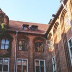 a red brick building with white window frames and ivy growing up the sides