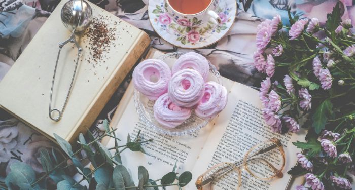 tea, pastries, books, flowers, and glasses