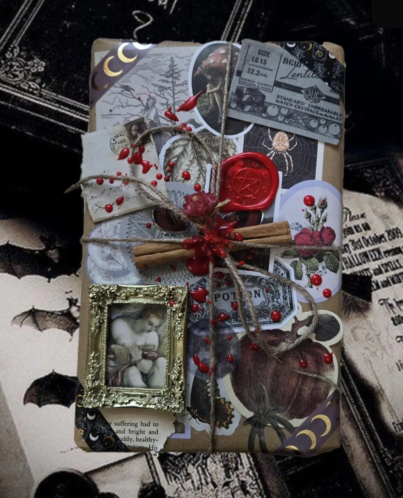 a book wrapped in brown paper and twine decorated with many witchy stickers, stationery, and a wax seal