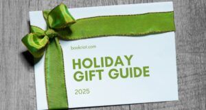 white gift box with a green bow ribbon and gold text on it that reads "bookriot.com holiday gift guide 2025"