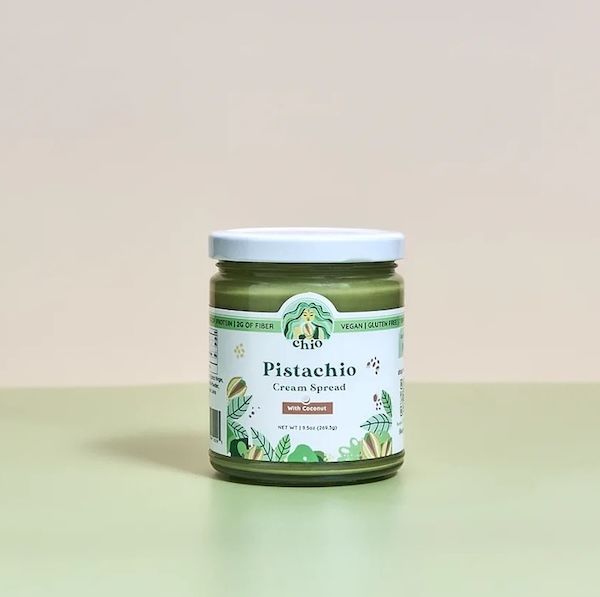 glass jar with a white lid containing coconut-flavored pistachio cream spread